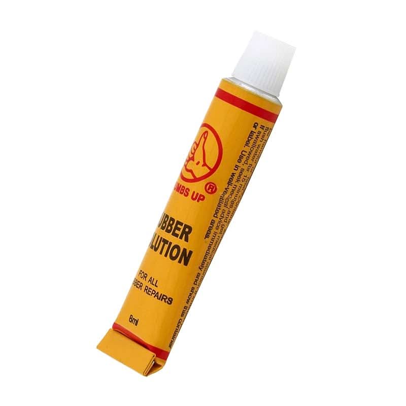 Inner Tube Patch & Repair Kit (Blemished): A yellow tube of rubber cement with a white cap, essential for patching punctured inner tubes, included in a comprehensive bike repair kit.