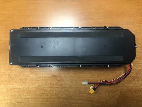 Lithium-ion Battery Pack for the Ninebot MAX G30 Scooter (Blemished), featuring a black rectangular unit with attached wires, lying on a wooden surface, showcasing visible electrical components.
