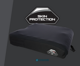 A dark gray Stealth glacial cushion with a textured honeycomb side panel and a cooling strap, shown with a 'SKIN PROTECTION' badge and a 'coolcore' brand logo on a dark gray background.