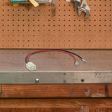 4-Pin, 2-Wire Battery Wiring Harness for Razor Scooters shown on a tool board with visible wires and wrenches, highlighting its connection capability for two 12-volt batteries in series.