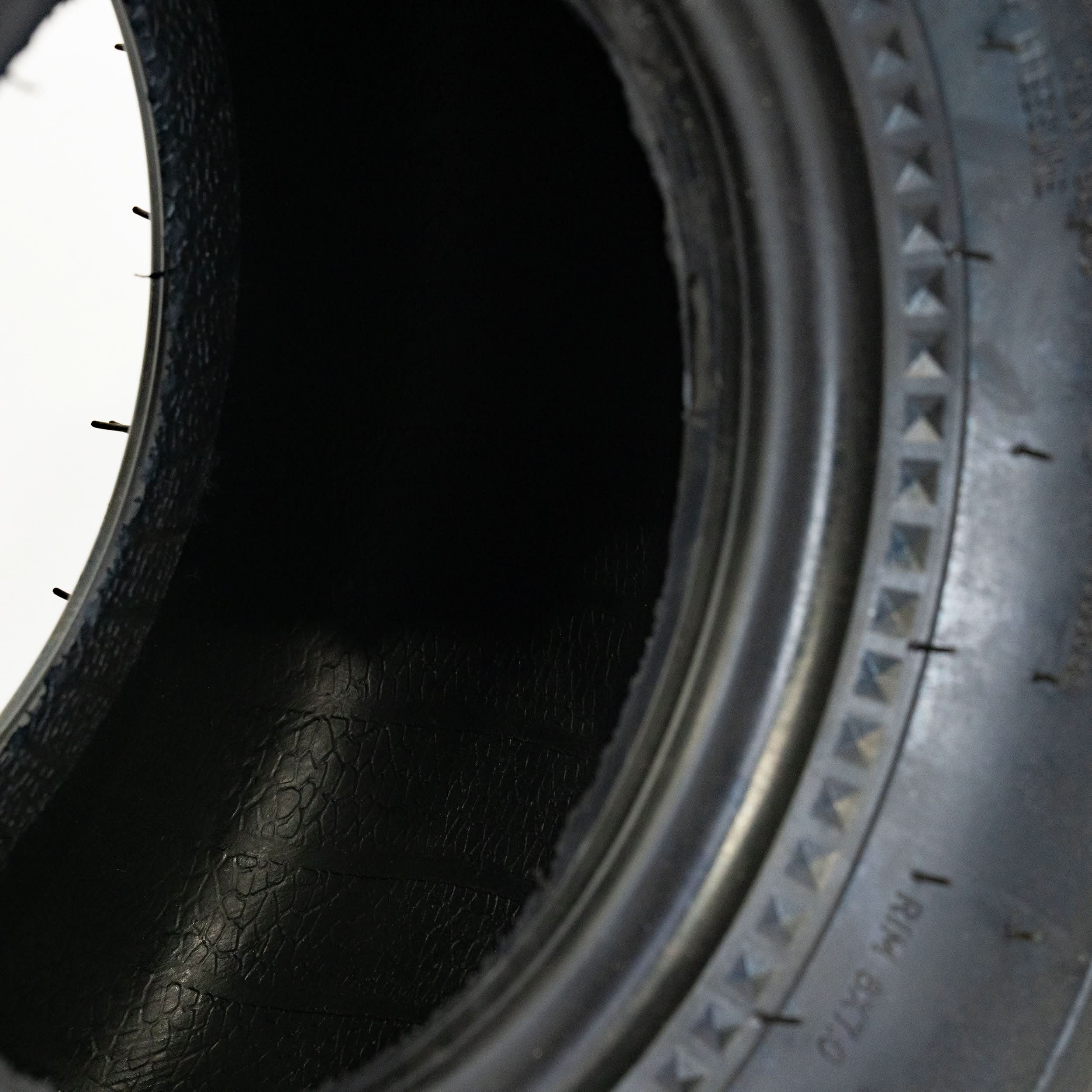 Close-up of the 18x9.5-8 Rear Tire for Coleman AT125-EX & AT125-UT ATVs, showcasing its knobby tread designed for effective performance on soft surfaces.