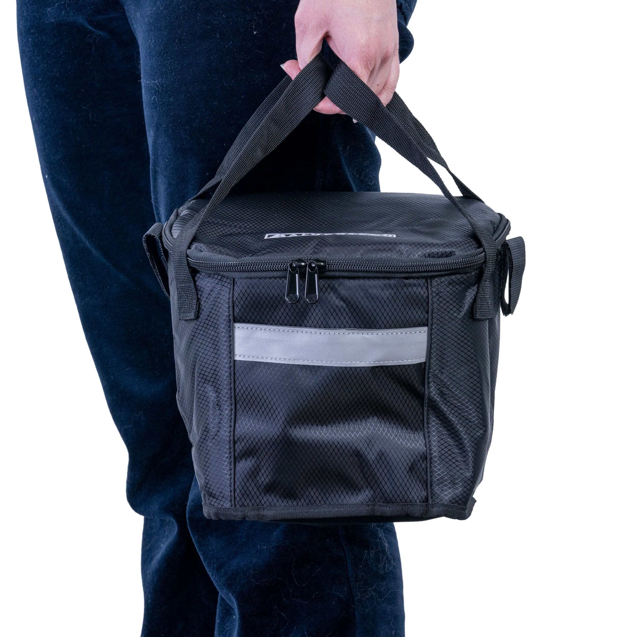A person holding the Insulated Front Basket Bag for Mobility Scooters, showcasing its sturdy ripstop polyester material, zippered main compartment, and leather label.