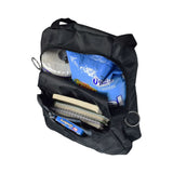 17x14 Backpack for Wheelchairs with six storage areas, visible items including a notebook, candy bar, chips, and toilet paper. Features adjustable straps and easy pull O rings on zippers.