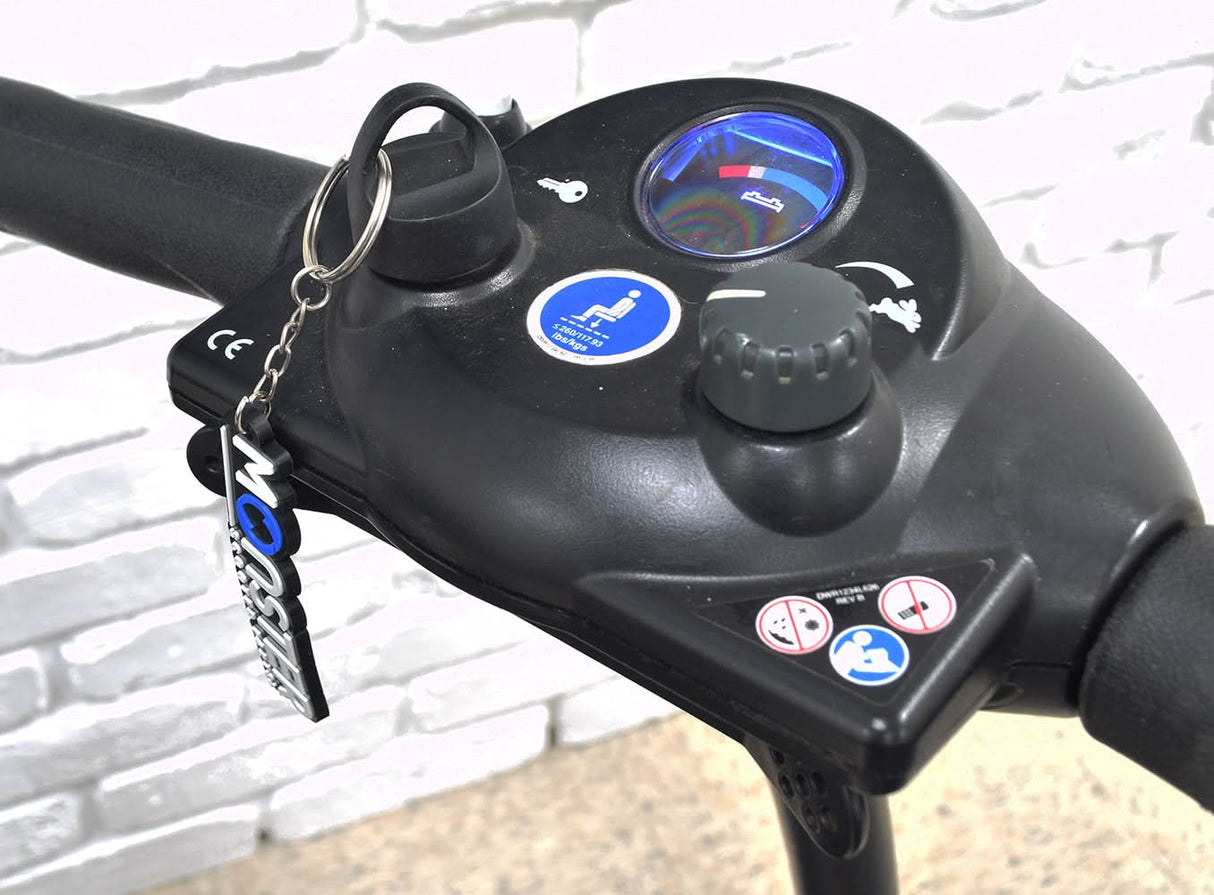 Deluxe Easy Pull Key for Pride and Go-Go Mobility Scooters shown attached to a bicycle handlebar, featuring a round black plastic knob and finger ring for easy handling.