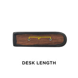 Black Vinyl Co-Molded Armrest Pad for Pride Scooters shown on a wooden surface with a yellow line, featuring a square end and a round end, designed to fit over the armrest weldment.